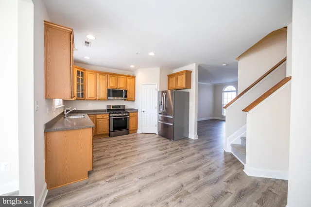 a kitchen with granite countertop a refrigerator and a stove top oven