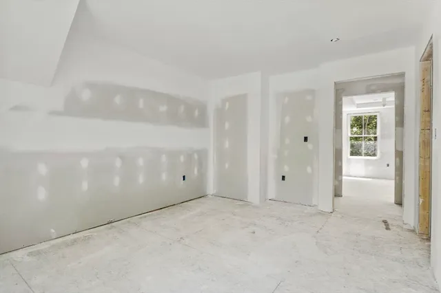 an empty room with closet and windows