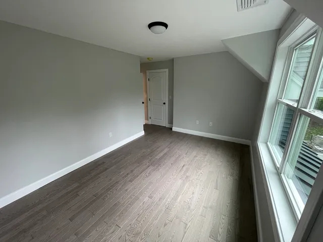 an empty room with windows and closet