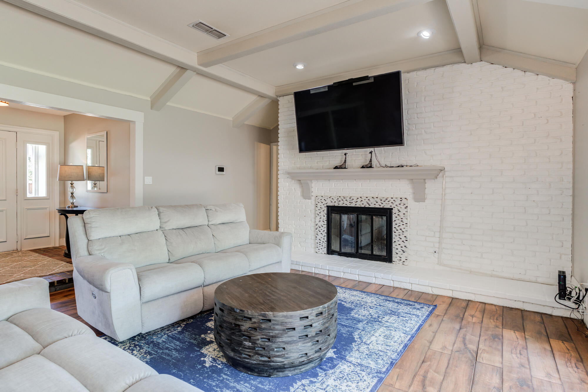 4507 8th Street Lubbock, TX 79416 - Photo 11 of 42 a living room with a fireplace and a flat screen tv