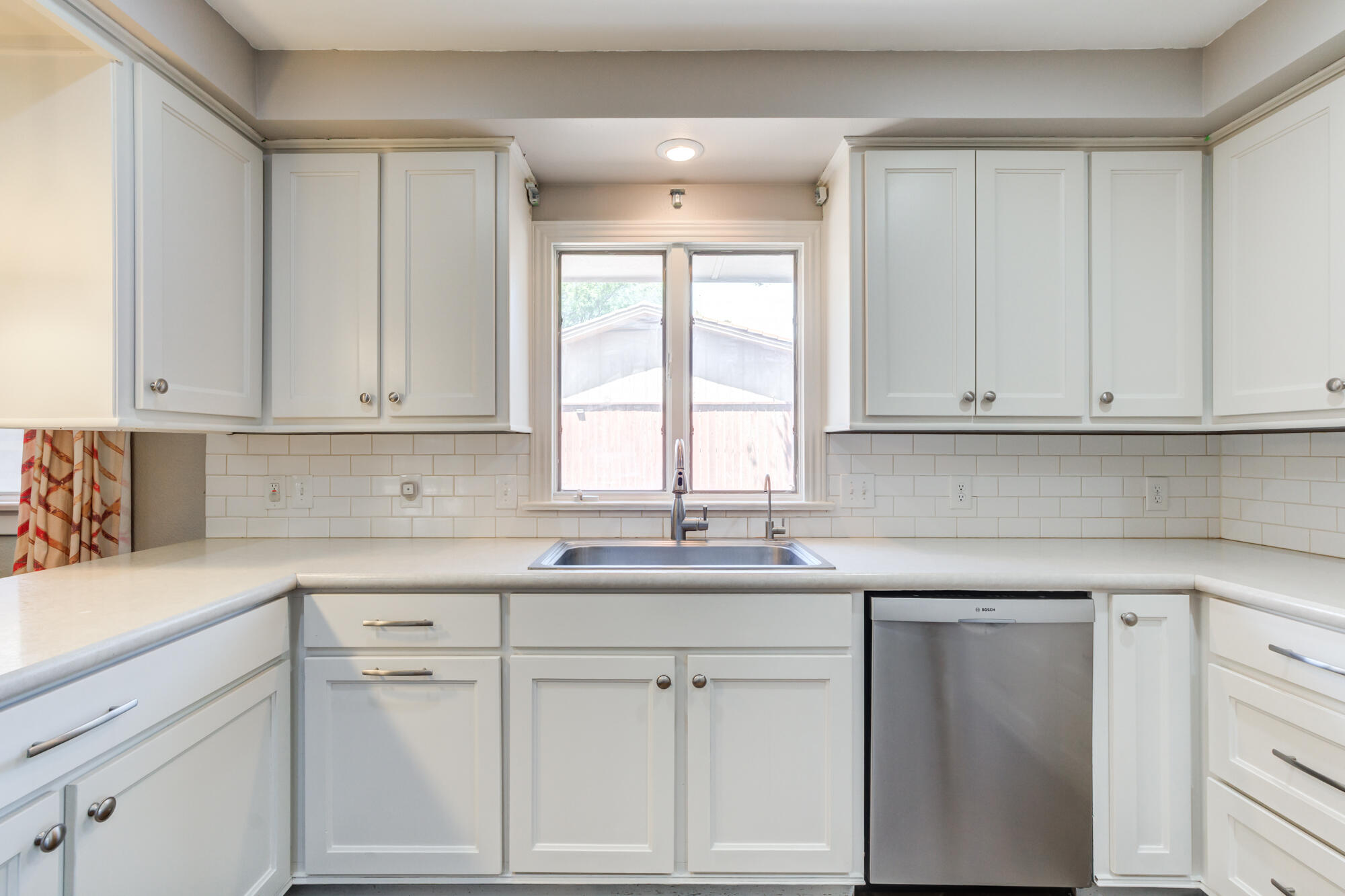 4507 8th Street Lubbock, TX 79416 - Photo 18 of 42 a kitchen with white cabinets and white appliances