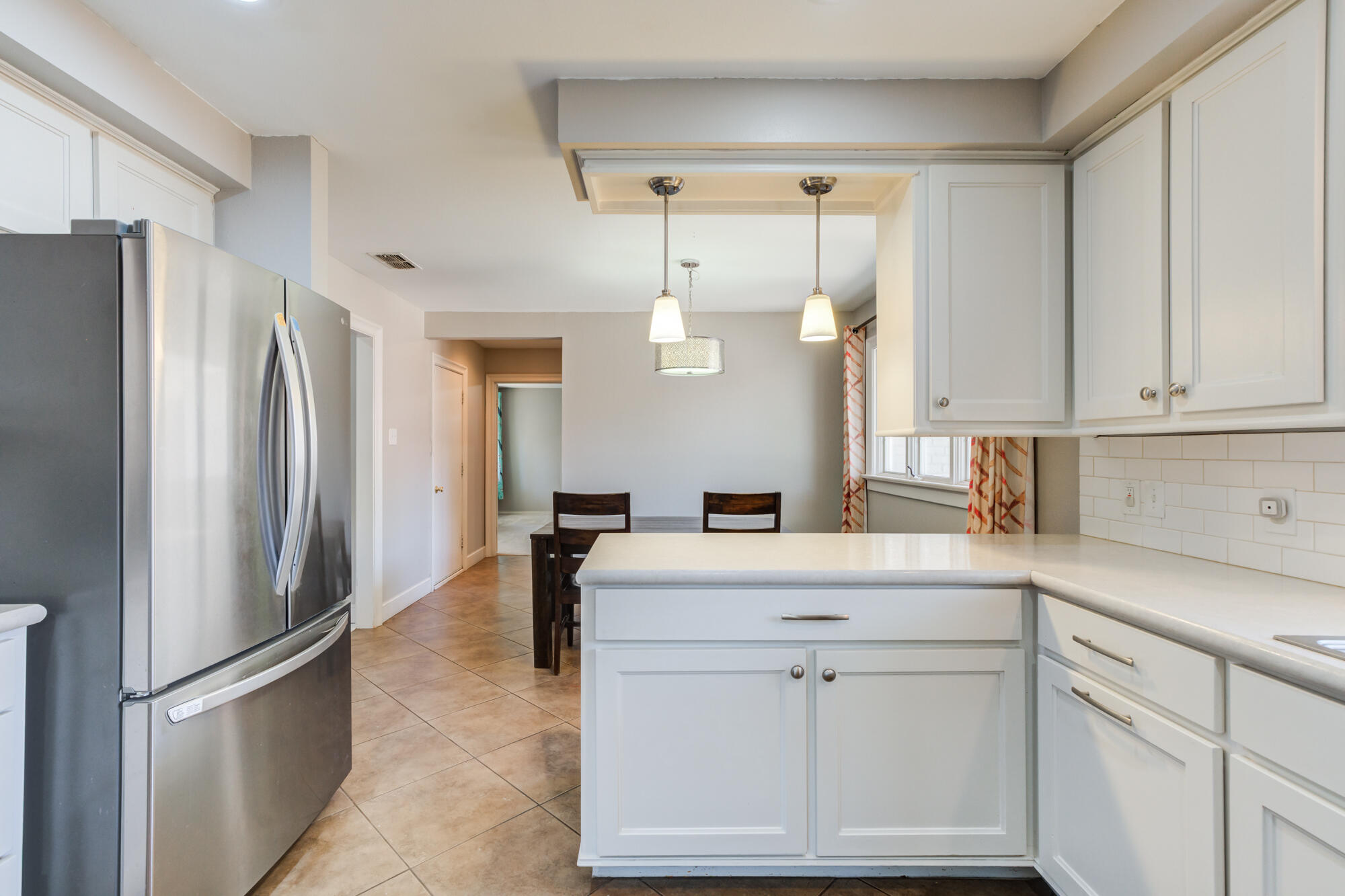 4507 8th Street Lubbock, TX 79416 - Photo 19 of 42 a kitchen with white cabinets and refrigerator
