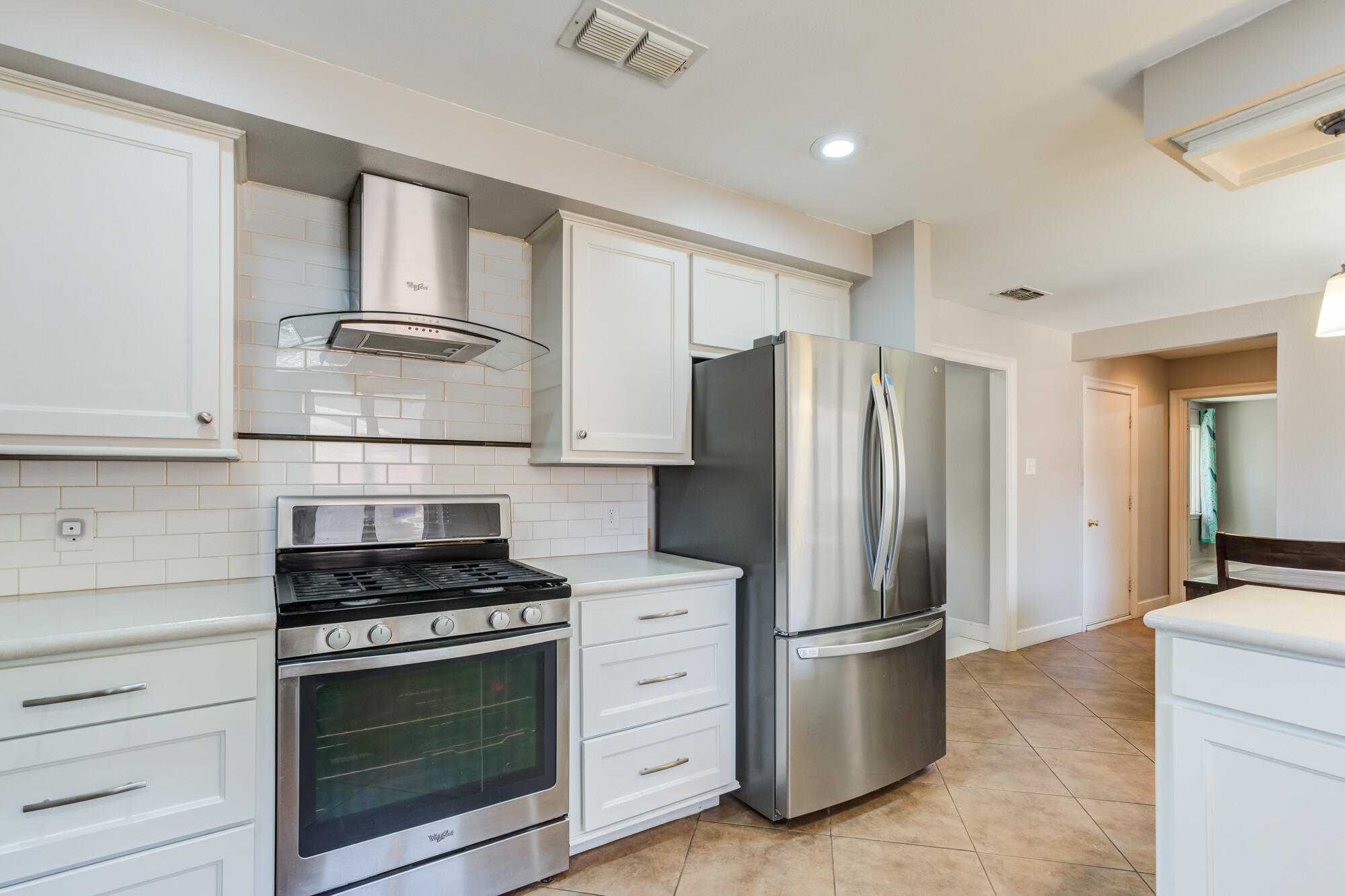 4507 8th Street Lubbock, TX 79416 - Photo 20 of 42 a kitchen with stainless steel appliances white cabinets and a refrigerator