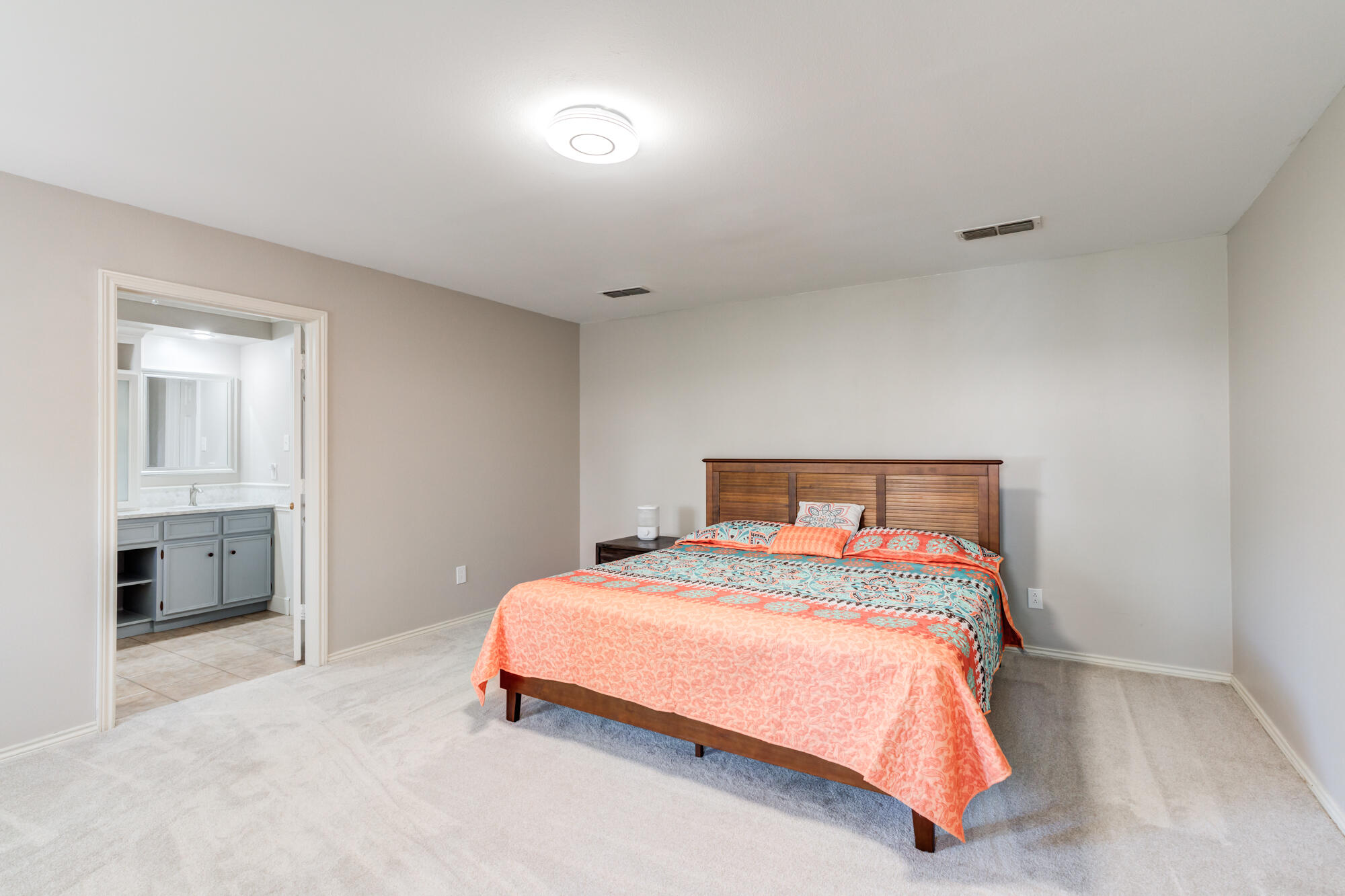 4507 8th Street Lubbock, TX 79416 - Photo 22 of 42 a bedroom with a bed and a lamp