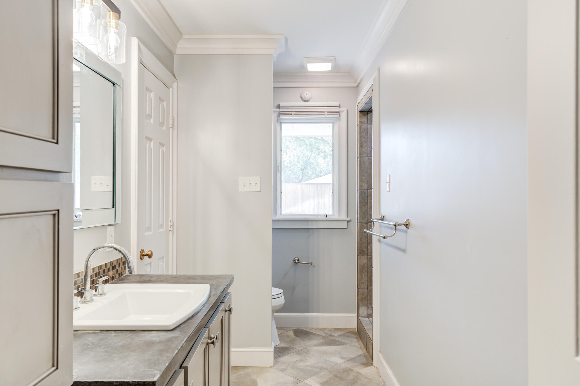 4507 8th Street Lubbock, TX 79416 - Photo 33 of 42 a bathroom with a sink and a mirror