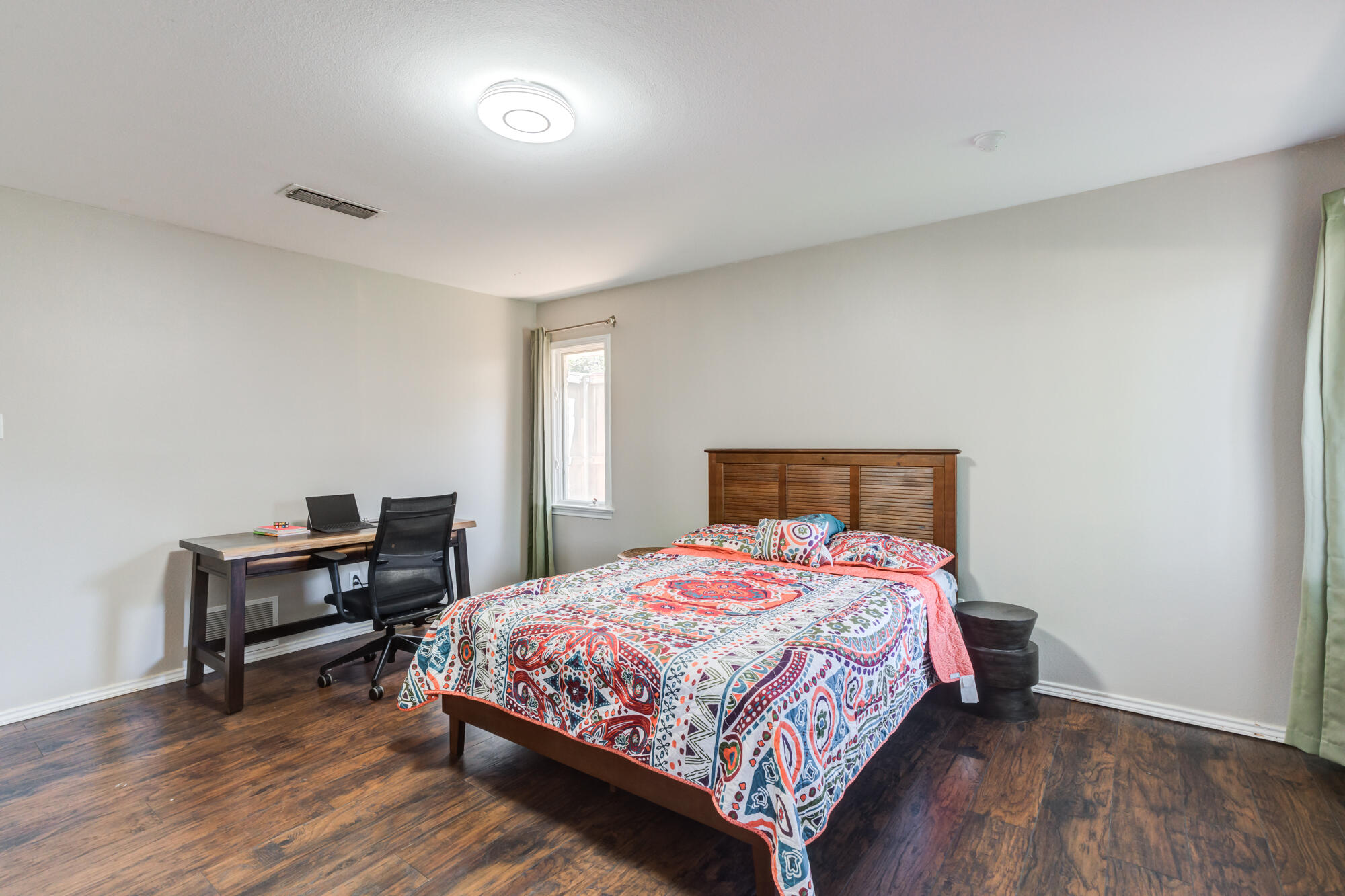 4507 8th Street Lubbock, TX 79416 - Photo 36 of 42 a bedroom with a bed and wooden floor