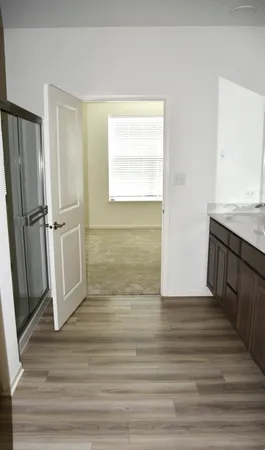 a view of empty room with wooden floor and window