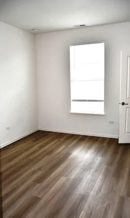 an empty room with wooden floor and a window