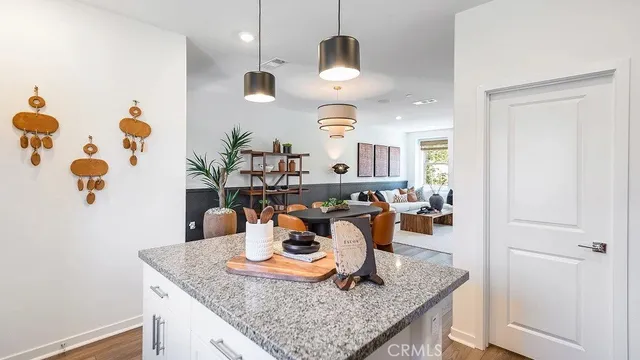 a dining room with wooden floor and chandelier