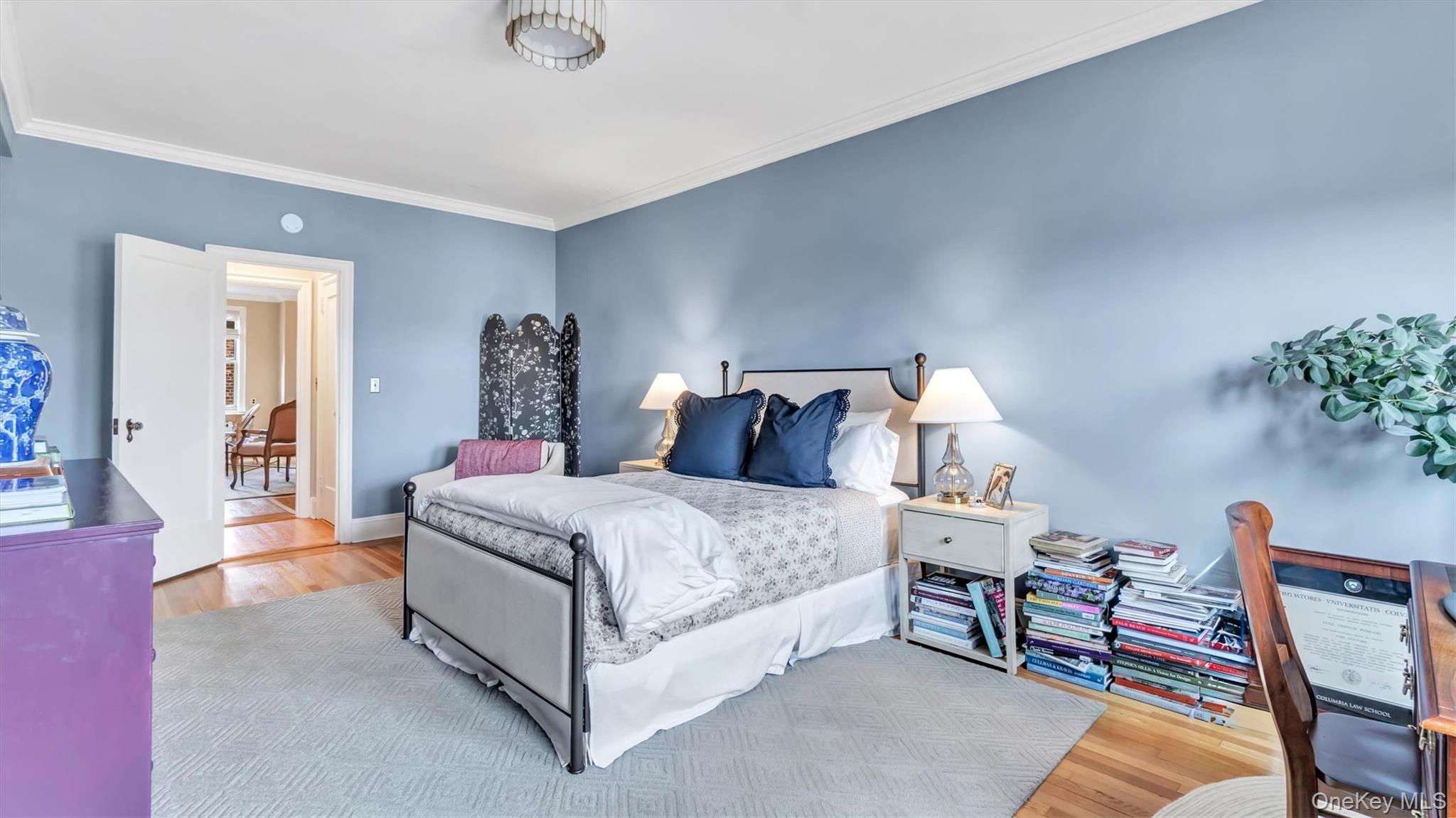 8 Barstow Road, Unit 7H Great Neck, NY 11021 - Photo 13 of 27 a spacious bedroom with a bed and a chandelier