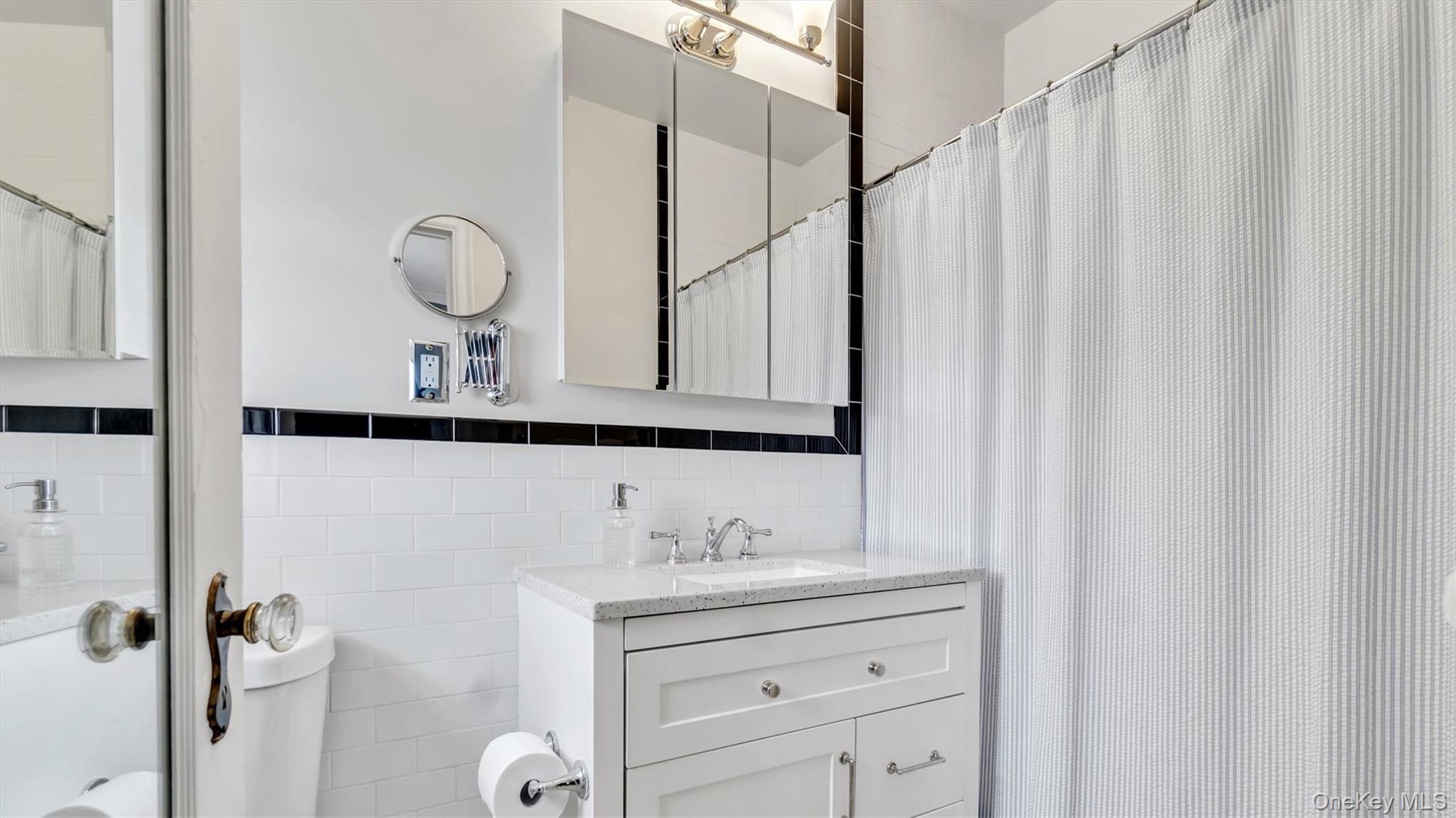 8 Barstow Road, Unit 7H Great Neck, NY 11021 - Photo 14 of 27 a bathroom with a sink vanity granite and a mirror