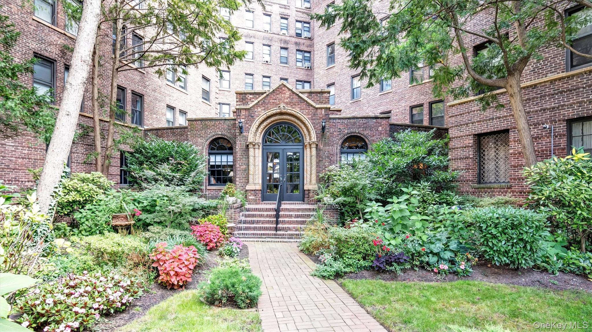 8 Barstow Road, Unit 7H Great Neck, NY 11021 - Photo 20 of 27 a front view of a house with a garden