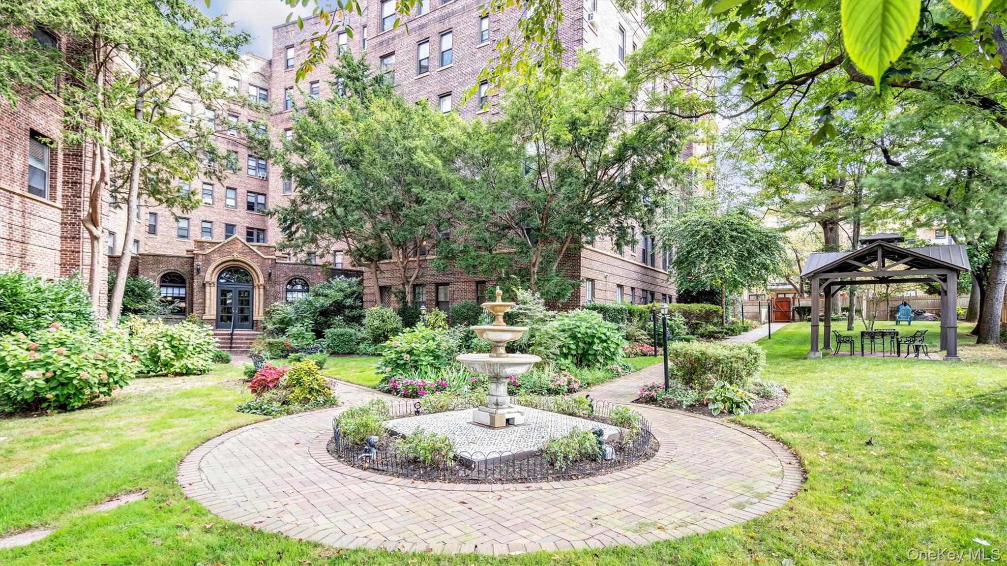 8 Barstow Road, Unit 7H Great Neck, NY 11021 - Photo 22 of 27 a front view of a house with a yard