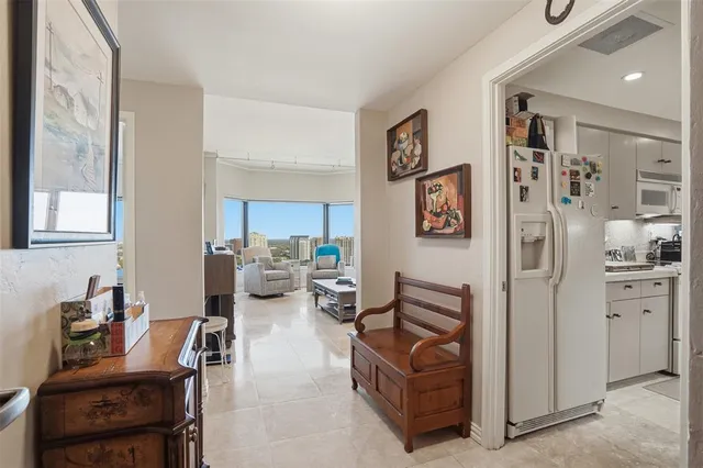 a living room with furniture and a refrigerator