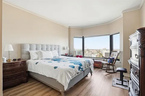 a bedroom with a bed a large window and walk in closet