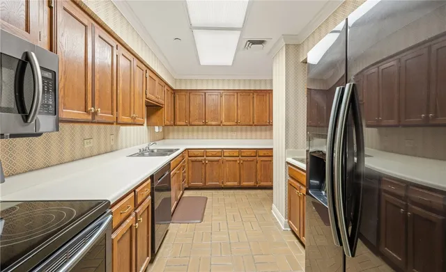 a kitchen with stainless steel appliances granite countertop a refrigerator a sink and wooden cabinets