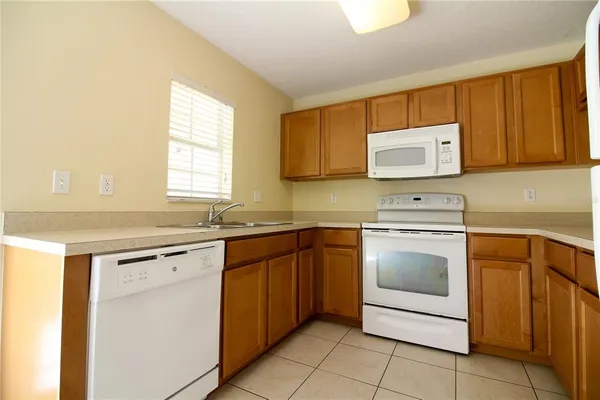 a kitchen with cabinets appliances a sink and a counter top space
