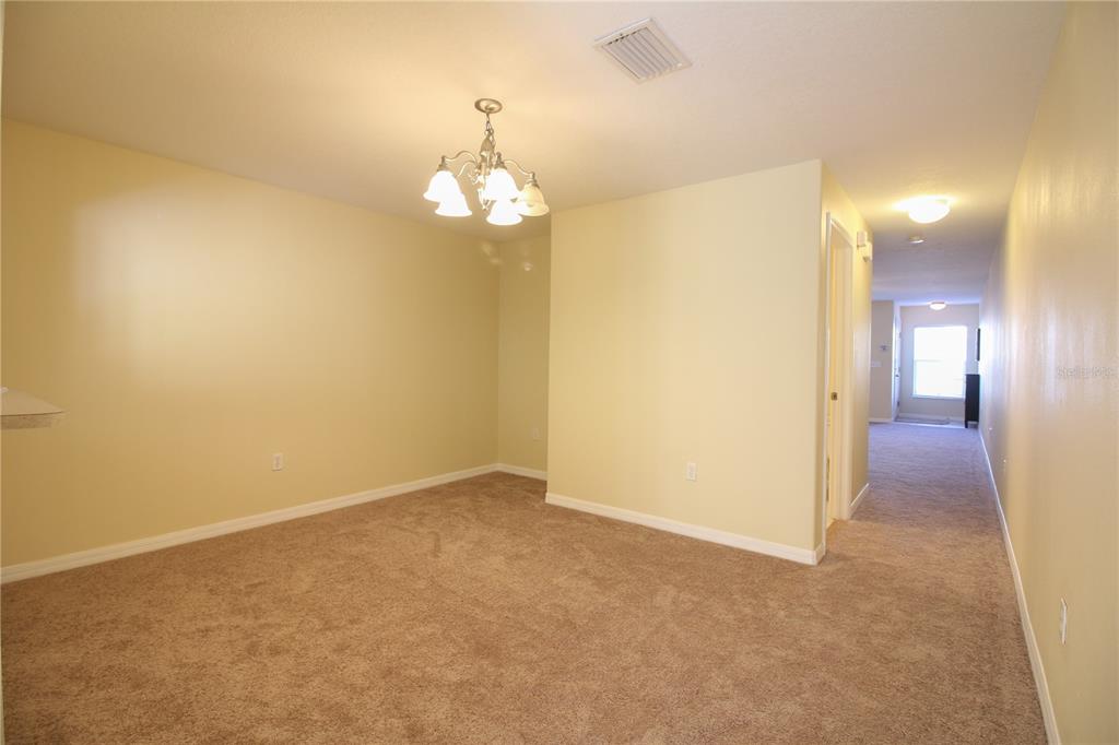 5433 Quarry Rock Road Lakeland, FL 33809 - Photo 8 of 26 an empty room with a chandelier fan and wooden floor