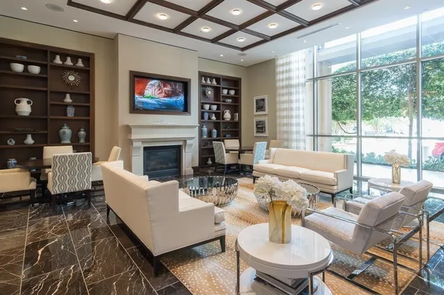 a living room with fireplace furniture and a large window