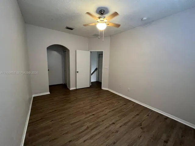 a view of empty room with wooden floor