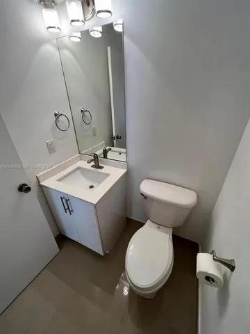 a bathroom with a sink vanity mirror and toilet
