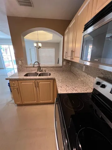 a kitchen with a sink stove and mirror