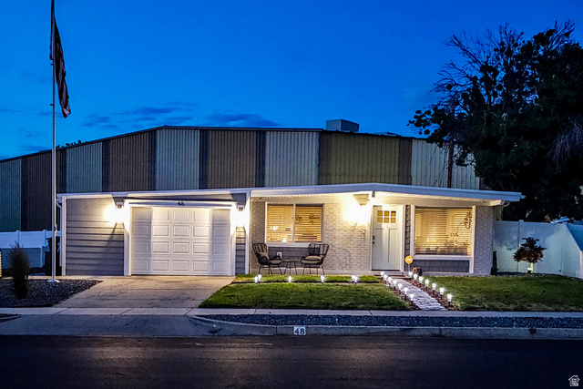 48 Moon Ridge Drive Murray, UT 84107 - Photo 2 of 30 Single-story residence featuring a white paneled garage door, a patterned front door with transom window, and exterior lighting accents