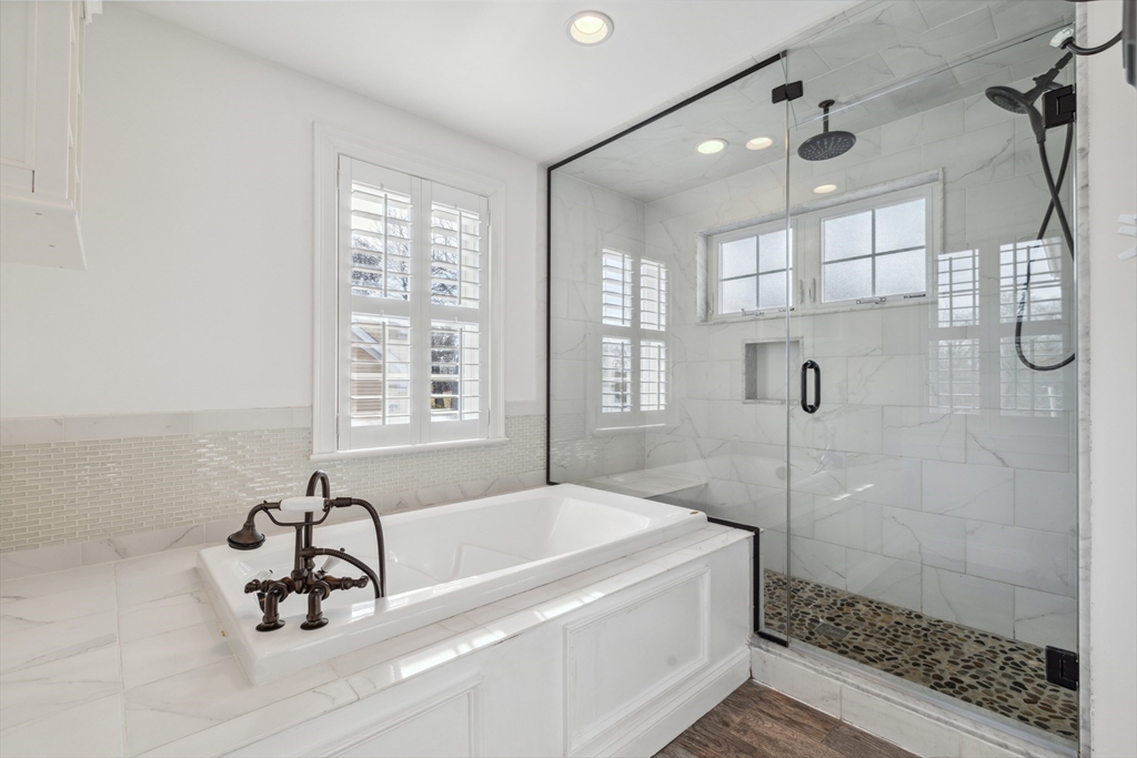 83 County Road Reading, MA 01867 - Photo 32 of 42 a bathroom with a tub a window and a glass door shower