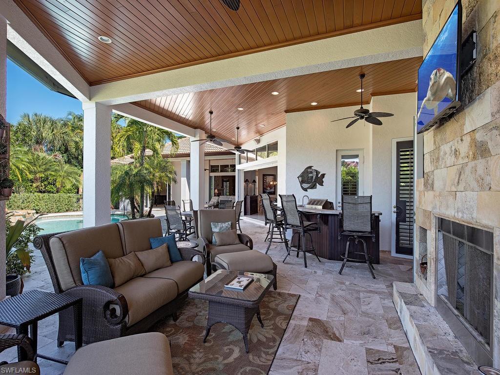 7347 Stonegate Drive Naples, FL 34109 - Photo 15 of 20 a living room with furniture fireplace and a table