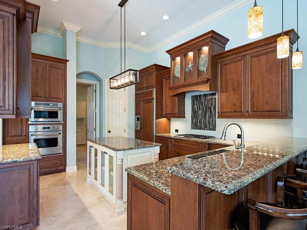 7347 Stonegate Drive Naples, FL 34109 - Photo 5 of 20 a kitchen with stainless steel appliances granite countertop a sink stove and refrigerator