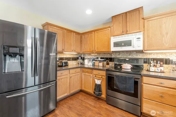 a kitchen with stainless steel appliances granite countertop a refrigerator stove and sink