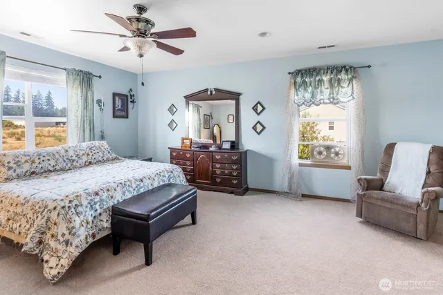 a spacious bedroom with a bed a couch and a window