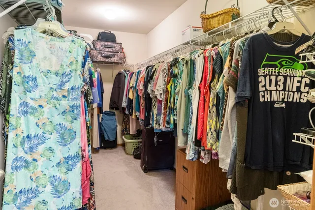 a view of walk in closet with clothes