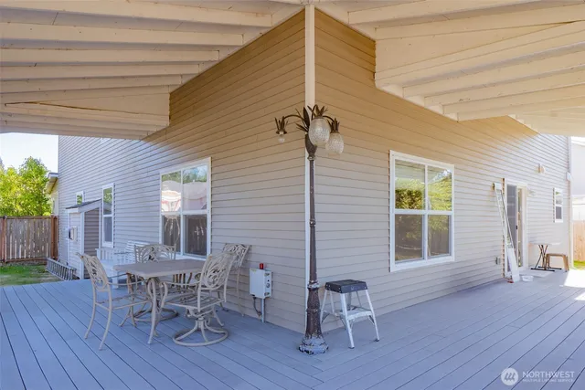a balcony with wooden floor table and chairs
