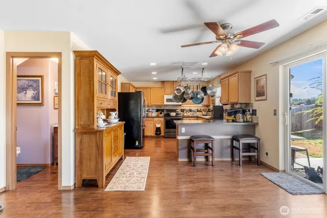 a living room with stainless steel appliances furniture a dining table and kitchen view