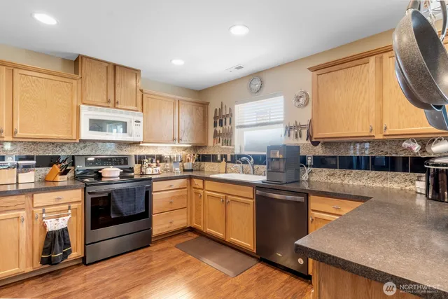 a kitchen with stainless steel appliances granite countertop a stove a sink and a microwave