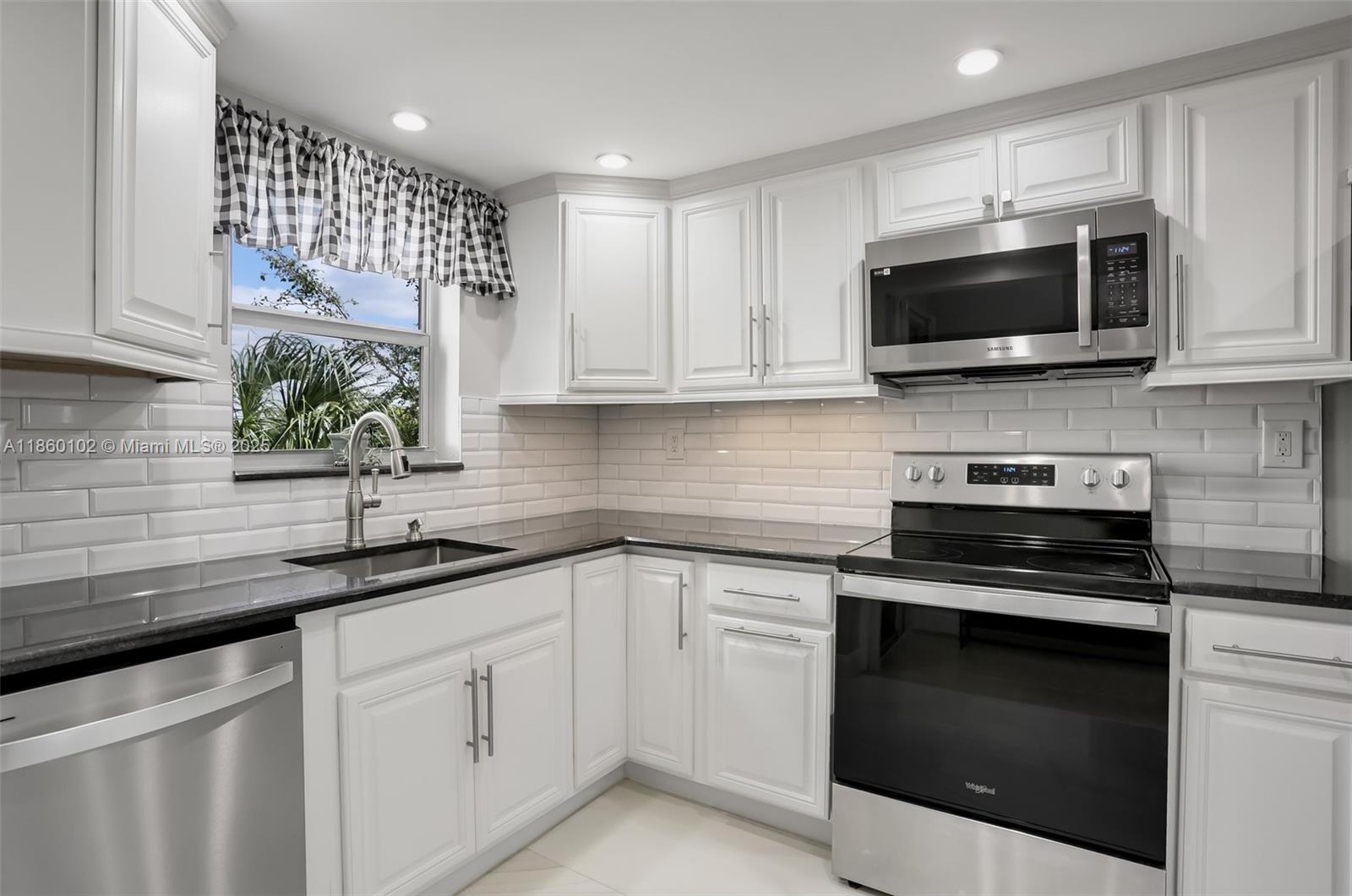 6020 Northwest 44th Street, Unit 401 Lauderhill, FL 33319 - Photo 17 of 35 a kitchen with white cabinets and stainless steel appliances