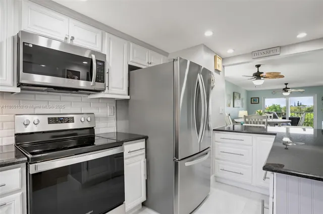 a kitchen with white cabinets stainless steel appliances and a sink