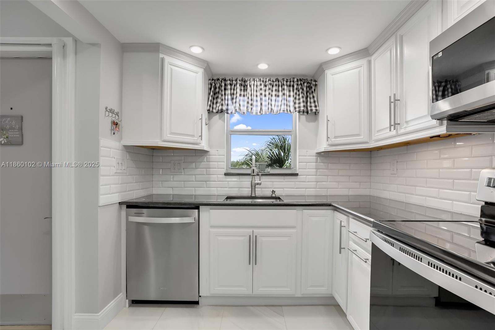 6020 Northwest 44th Street, Unit 401 Lauderhill, FL 33319 - Photo 19 of 35 a kitchen with white cabinets stainless steel appliances and a sink