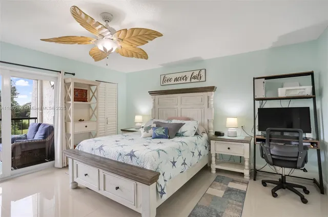 a bedroom with a bed a flat screen tv and a fish tank on dresser