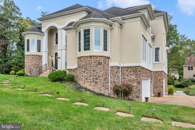 a white house covered with tall trees