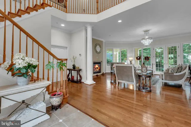 a living room with furniture chandelier and a large window