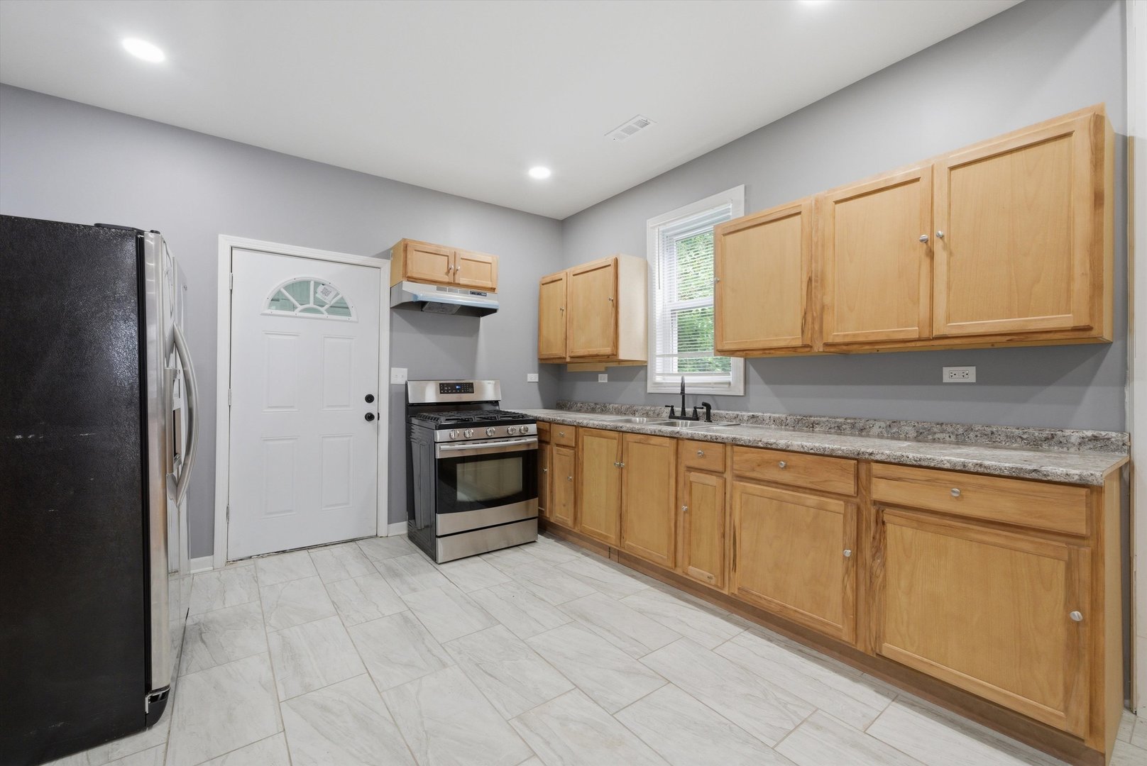 7828 South Escanaba Avenue Chicago, IL 60649 - Photo 14 of 41 a kitchen with granite countertop a refrigerator sink and cabinets