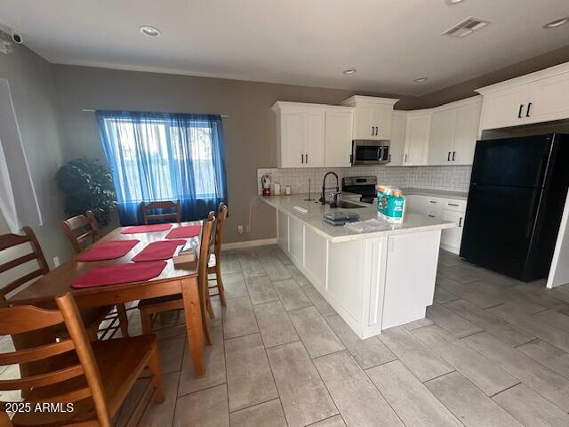 1908 South 14th Street Phoenix, AZ 85034 - Photo 6 of 18 a kitchen with stainless steel appliances kitchen island granite countertop a refrigerator a stove top oven a sink dishwasher and white cabinets