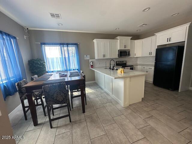 1908 South 14th Street Phoenix, AZ 85034 - Photo 7 of 18 a kitchen with stainless steel appliances kitchen island granite countertop a table chairs sink and cabinets