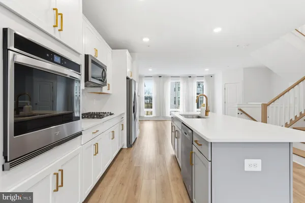 a large kitchen with stainless steel appliances kitchen island granite countertop a stove and a sink
