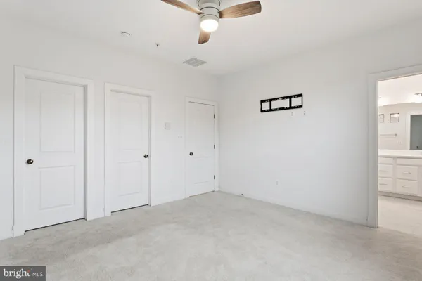 an empty room with a ceiling fan and window