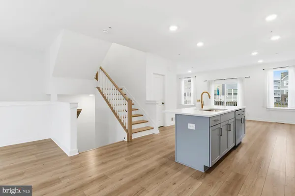a kitchen with wooden floors and white cabinets