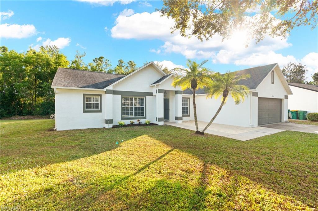 a view of a house with a yard and potted plants