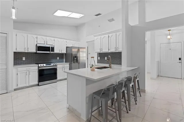 a living room with furniture kitchen view and a window